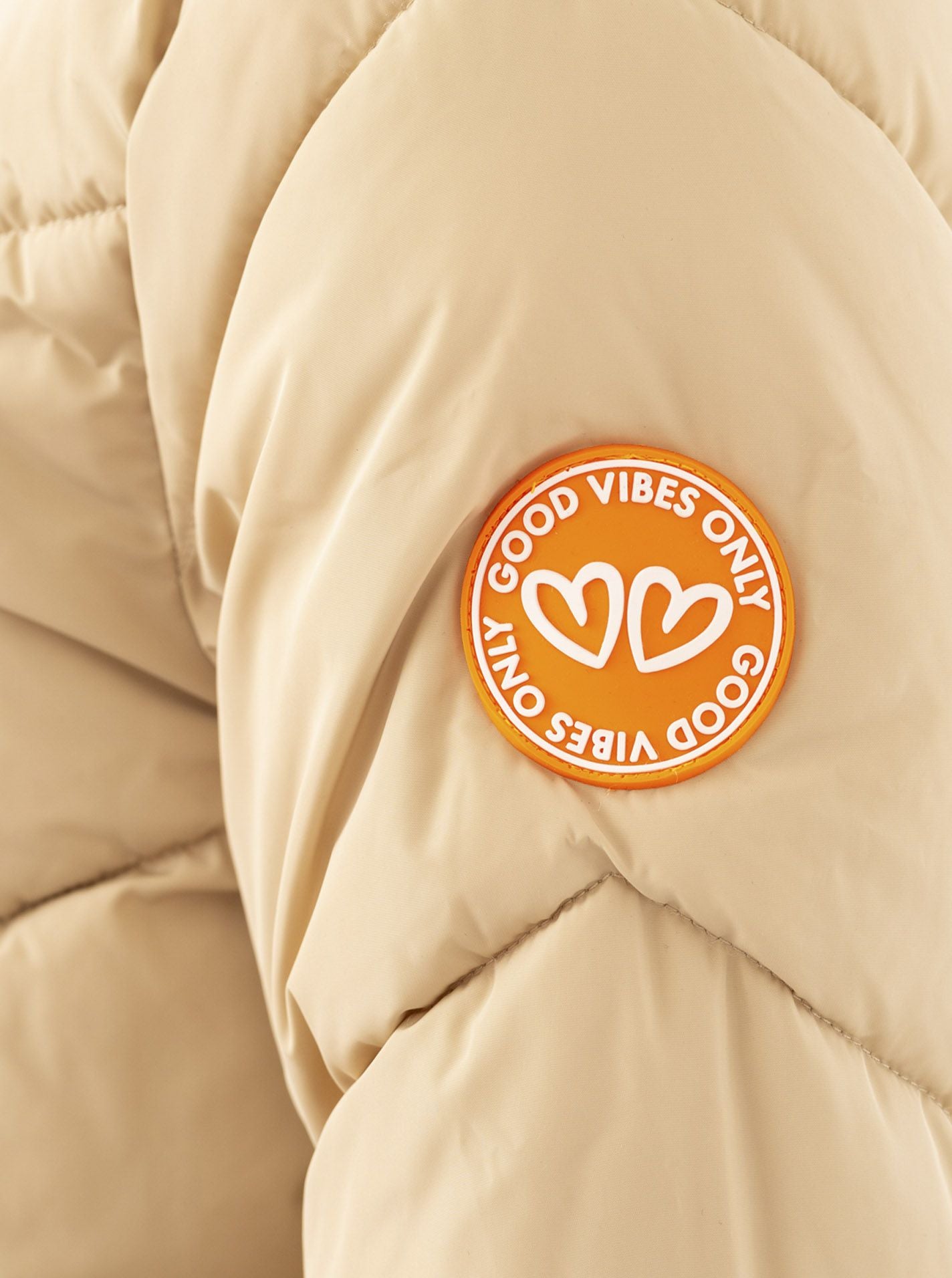 Detailansicht des Ärmels vom Zwillingsherz Steppmantel in Orange-Beige – sportlicher Look mit feiner Verarbeitung
