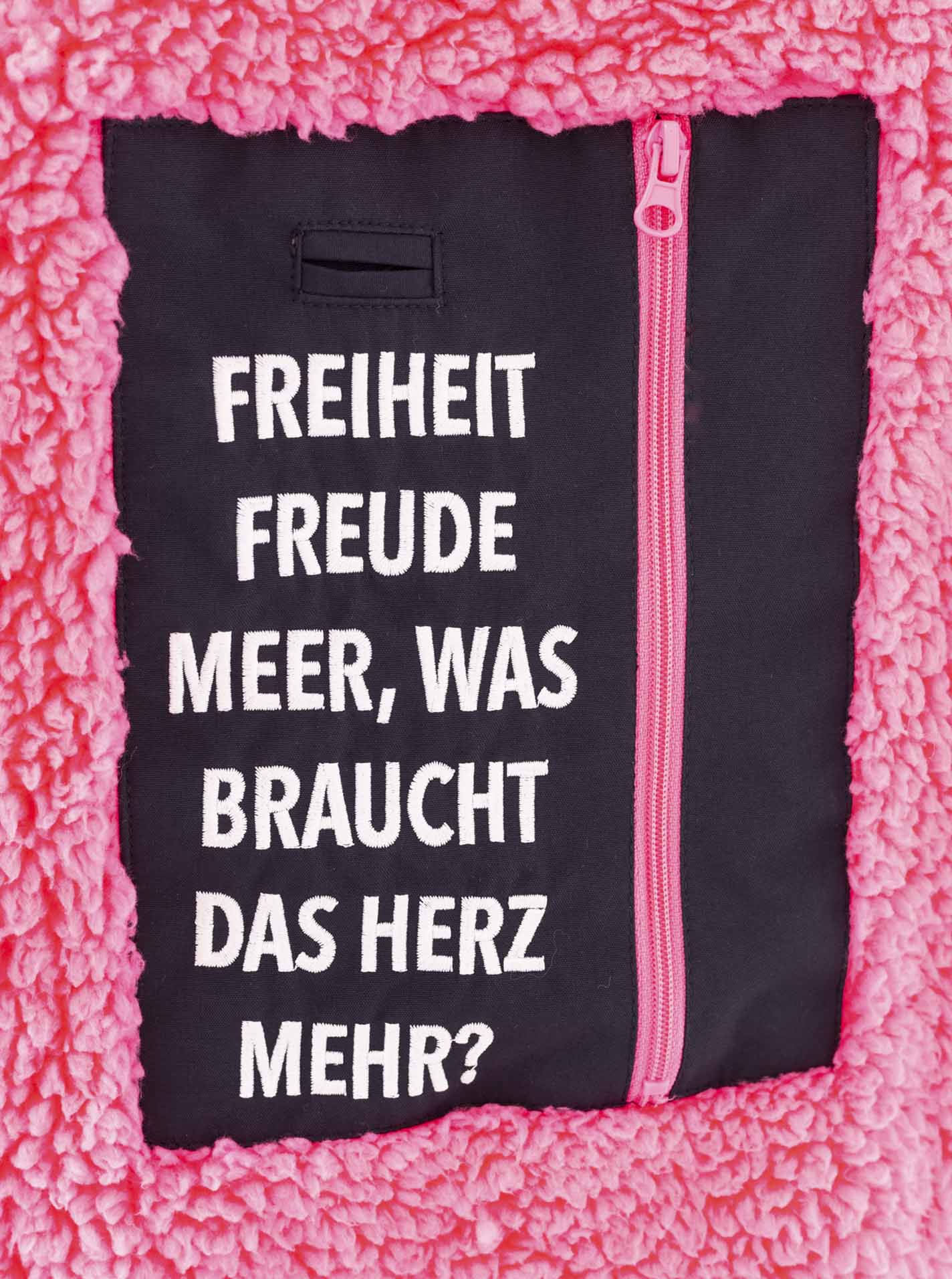 Detailansicht Spruch auf der Zwillingsherz Windjacke – dezenter Schriftzug auf Zipper oder Brust, stilvoll und markentypisch