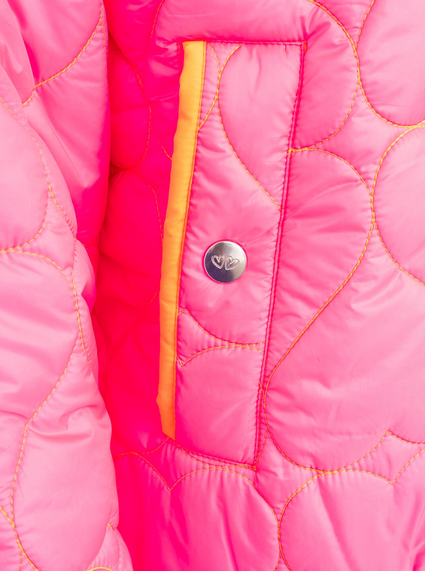 Zwillingsherz Stepp-Bomberjacke Be Happy in Neonpink, Detailansicht der Tasche mit femininem Herz-Steppmuster